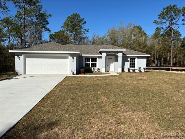 view of front of property featuring stucco siding, driveway, an attached garage, and a front yard