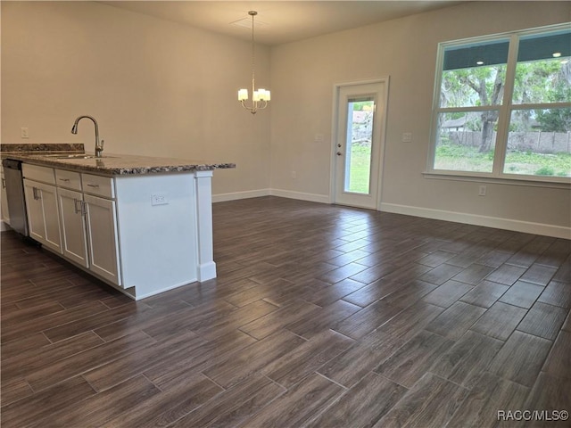 259 Bittern Loop, Inverness, FL 34453 - kitchen with a sink, dark wood finished floors, a chandelier, dark stone countertops, and baseboards