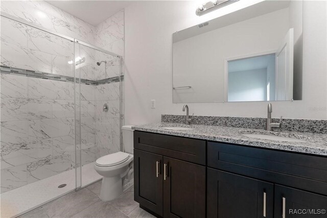 bathroom with walk in shower, vanity, and toilet