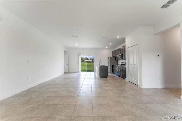 unfurnished living room with sink and light tile patterned floors