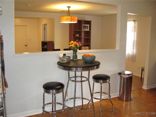 interior space with a peninsula, a breakfast bar, and baseboards