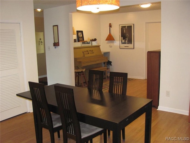 dining space with wood finished floors and baseboards