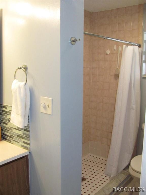 full bathroom featuring toilet, a shower stall, decorative backsplash, and vanity