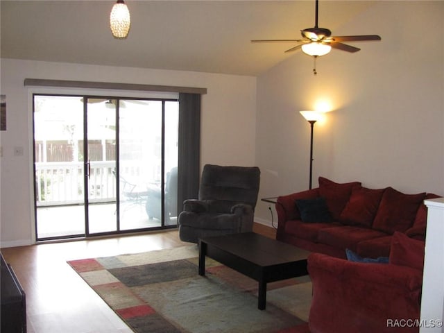 living area featuring vaulted ceiling, ceiling fan, and light wood finished floors