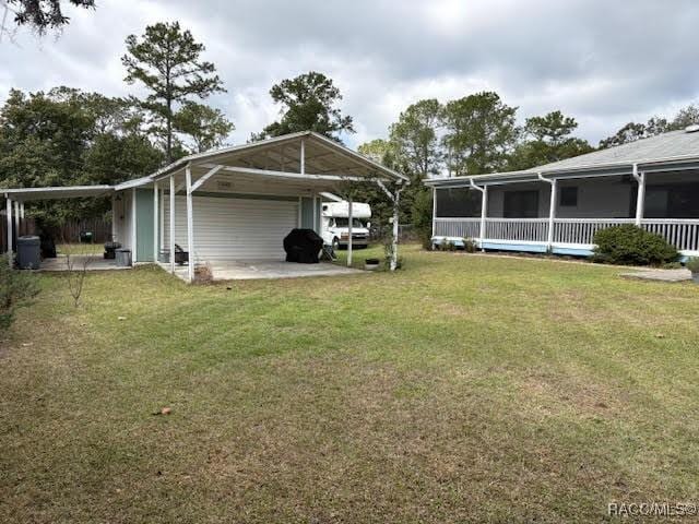 view of yard with a carport and driveway