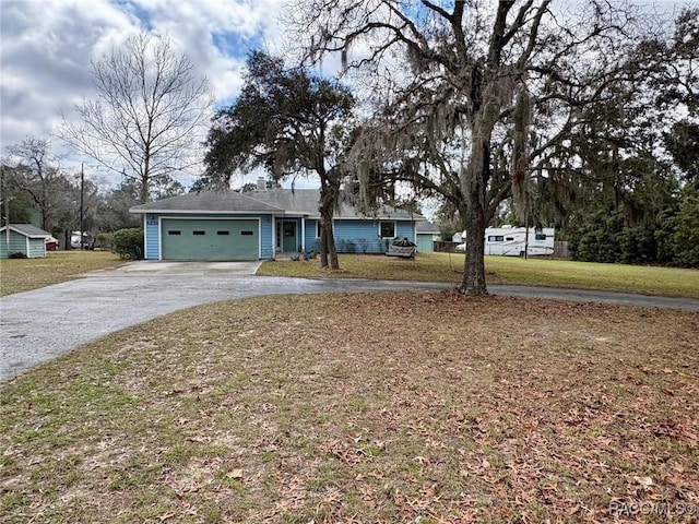 ranch-style home with driveway, an attached garage, and a front yard