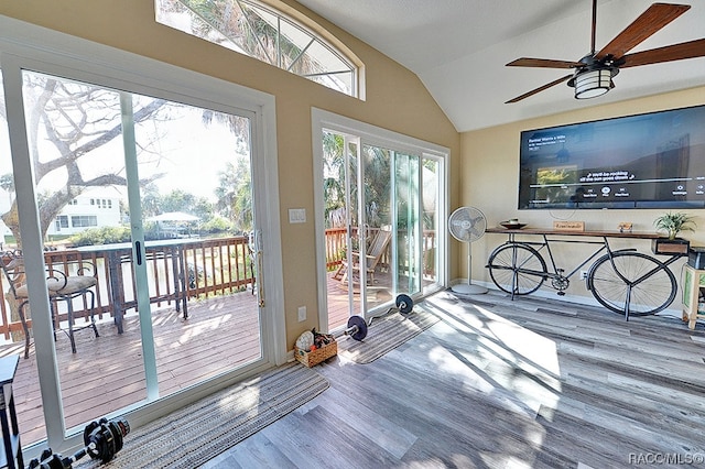 doorway to outside with ceiling fan, wood-type flooring, and vaulted ceiling