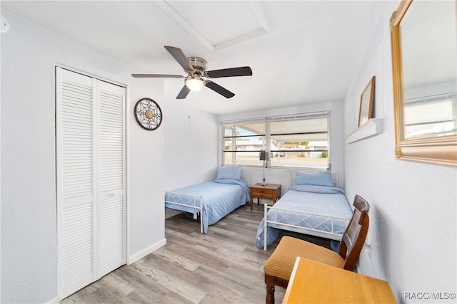 bedroom with ceiling fan, a closet, and light hardwood / wood-style flooring