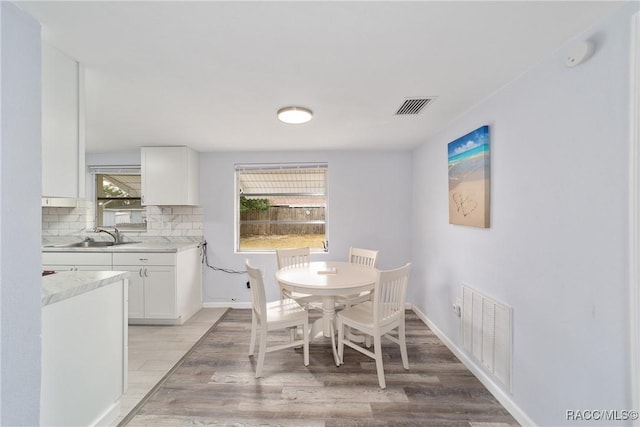 dining area with sink and light hardwood / wood-style flooring