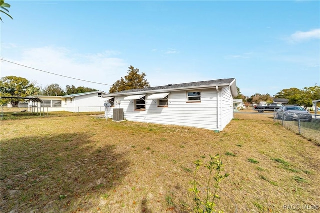 back of property featuring central air condition unit and a lawn