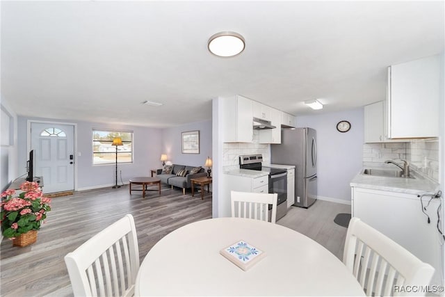 dining room with light wood-type flooring and sink