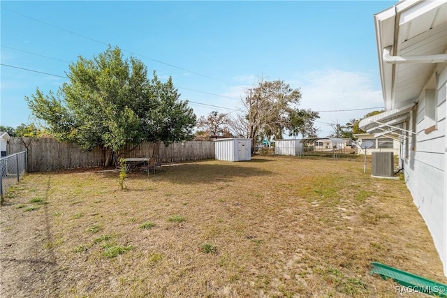 view of yard with central AC and a storage shed