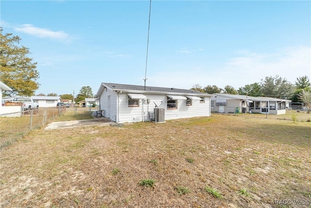 back of property with cooling unit and a yard