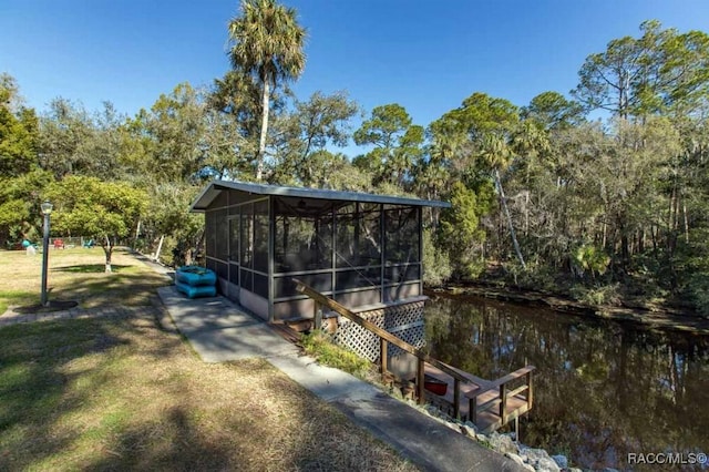 exterior space featuring a water view and a sunroom