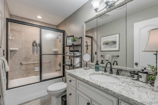 full bathroom featuring vanity, tile patterned flooring, bath / shower combo with glass door, and toilet