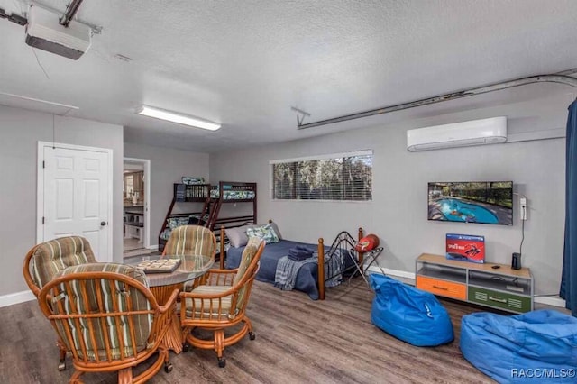 interior space featuring hardwood / wood-style floors, a wall mounted air conditioner, and a textured ceiling