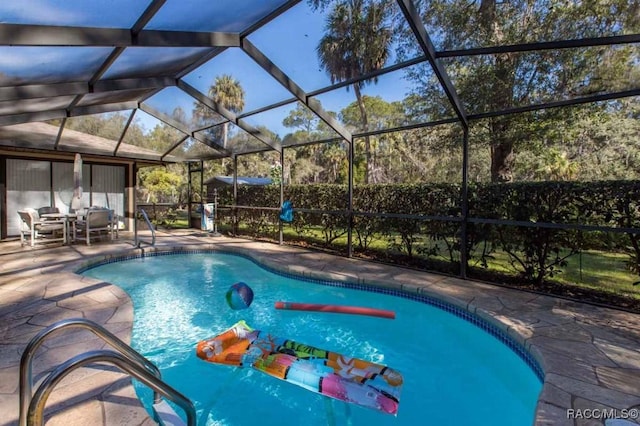 view of swimming pool featuring a lanai and a patio area