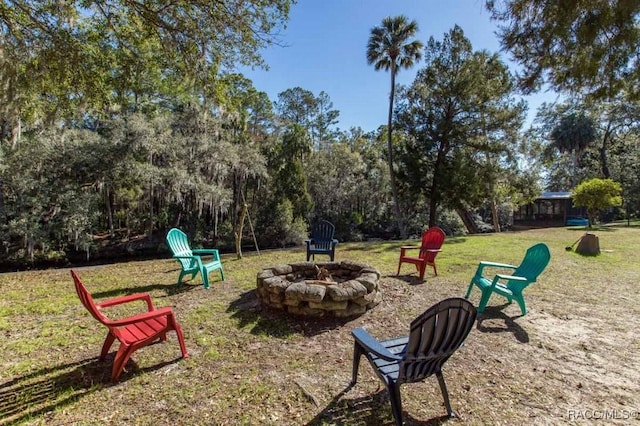 view of community featuring a lawn and a fire pit