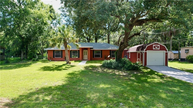 ranch-style home featuring an outbuilding, driveway, a detached garage, and a front lawn