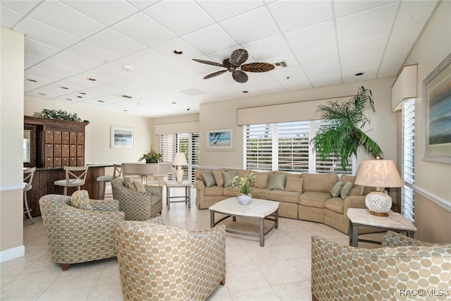 tiled living room featuring a drop ceiling and ceiling fan