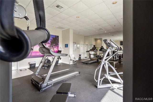 gym with a drop ceiling, visible vents, and baseboards