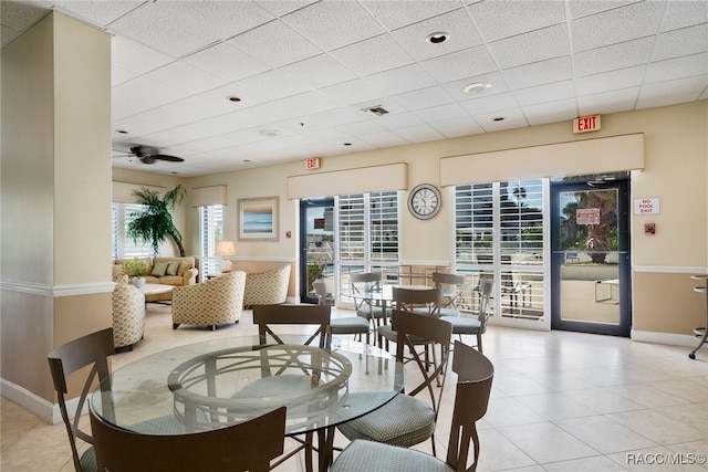 dining area with ceiling fan, light tile patterned floors, a paneled ceiling, visible vents, and baseboards