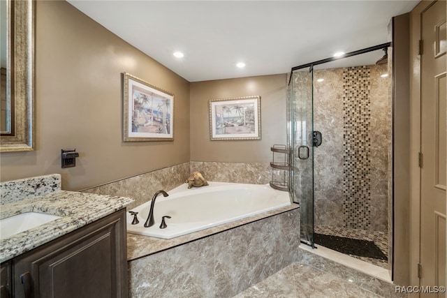 bathroom with vanity, a shower stall, a bath, and recessed lighting