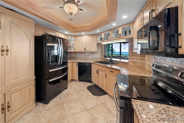 9950 S Ocean Dr Unit 302, Jensen Beach, FL 34957 - kitchen featuring black appliances, light brown cabinetry, a sink, tasteful backsplash, and a tray ceiling