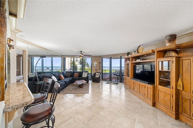 9950 S Ocean Dr Unit 302, Jensen Beach, FL 34957 - living room with light tile patterned flooring, a ceiling fan, and a textured ceiling