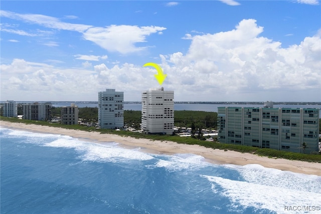 drone / aerial view with a city view, a water view, and a beach view