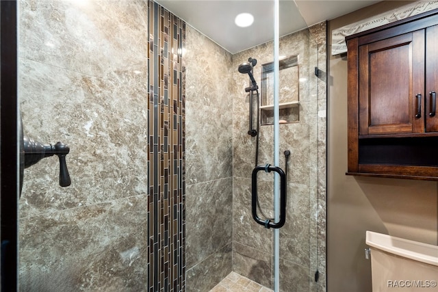 bathroom with a stall shower and toilet