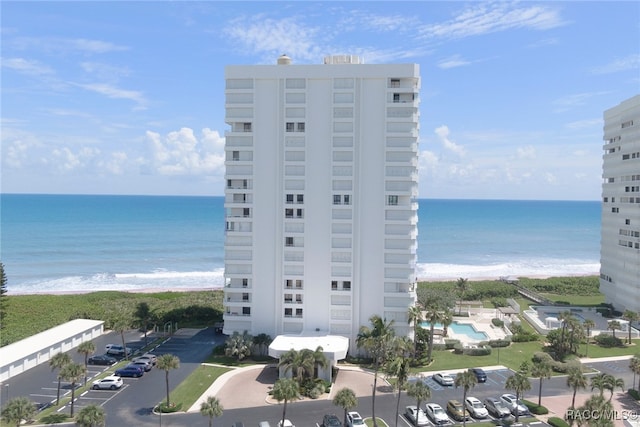 view of property with a water view and a view of the beach