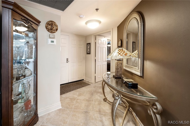 interior space featuring light tile patterned floors, visible vents, and baseboards