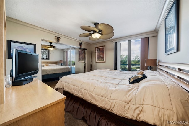 bedroom with carpet, a textured ceiling, ceiling fan, crown molding, and a closet