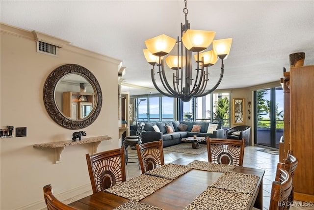 tiled dining area with crown molding, a textured ceiling, and an inviting chandelier