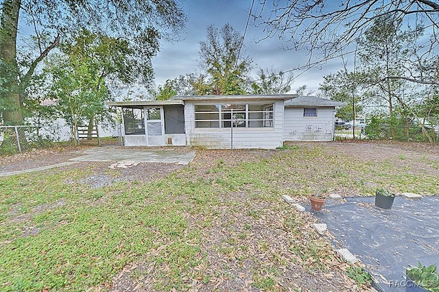 view of front of home featuring fence and a sunroom