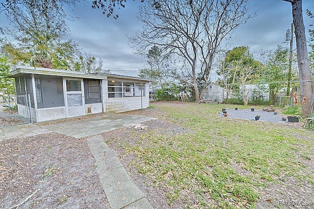 view of yard with fence and a sunroom