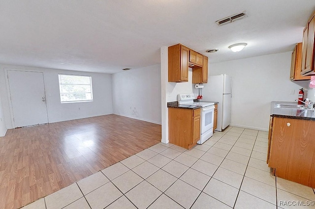 kitchen with visible vents, white appliances, dark countertops, and open floor plan