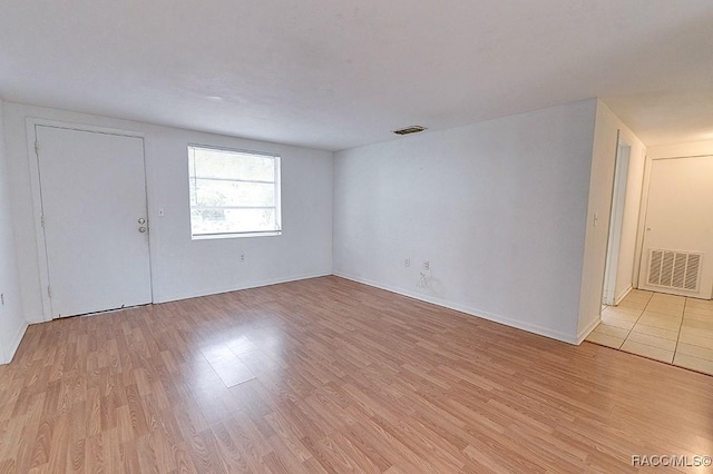 unfurnished room with baseboards, visible vents, and light wood finished floors