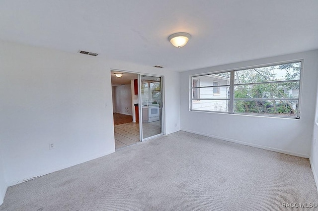 unfurnished room with tile patterned floors, baseboards, visible vents, and carpet floors