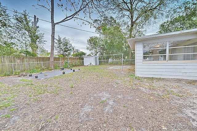 view of yard with an outdoor structure, a fenced backyard, and a storage shed