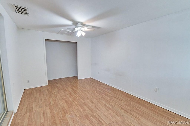 unfurnished room featuring light wood-type flooring, baseboards, visible vents, and ceiling fan