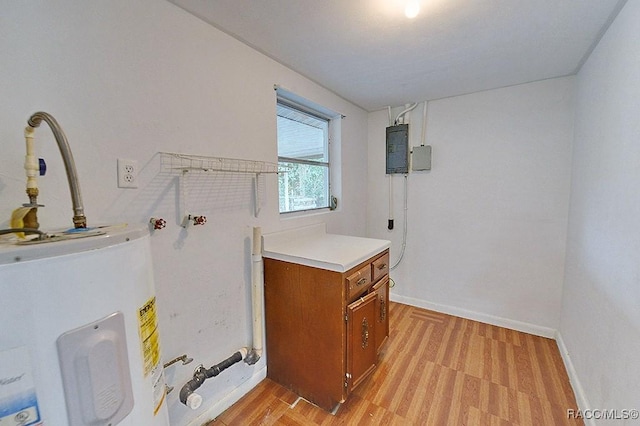 clothes washing area featuring light wood-type flooring, electric panel, water heater, baseboards, and laundry area