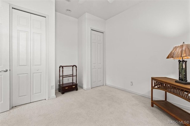 interior space featuring ceiling fan, two closets, and baseboards