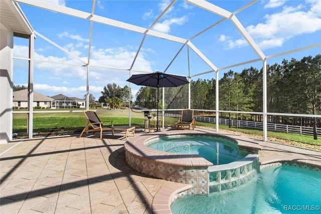 view of swimming pool featuring a pool with connected hot tub, a lanai, a patio, and fence