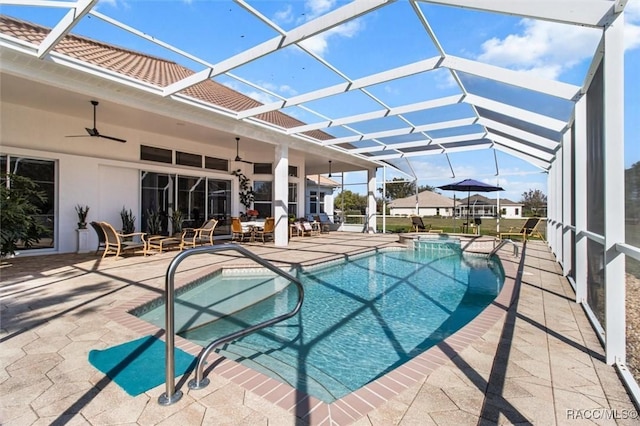 view of swimming pool with a ceiling fan, glass enclosure, and a patio