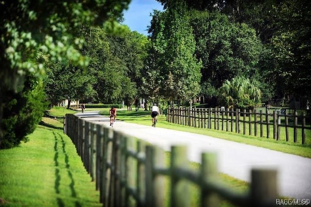 view of home's community with fence and a yard