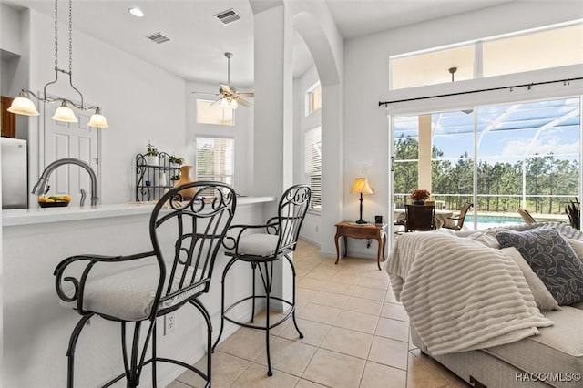 dining space with light tile patterned floors, a wealth of natural light, and visible vents