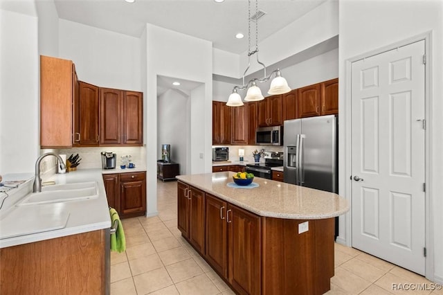 kitchen with light tile patterned floors, stainless steel appliances, decorative backsplash, a sink, and a kitchen island