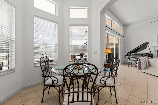 dining area with light tile patterned floors, baseboards, and arched walkways